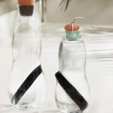 2 glass bottles with the Black + Blum charcoal filters with coil inside