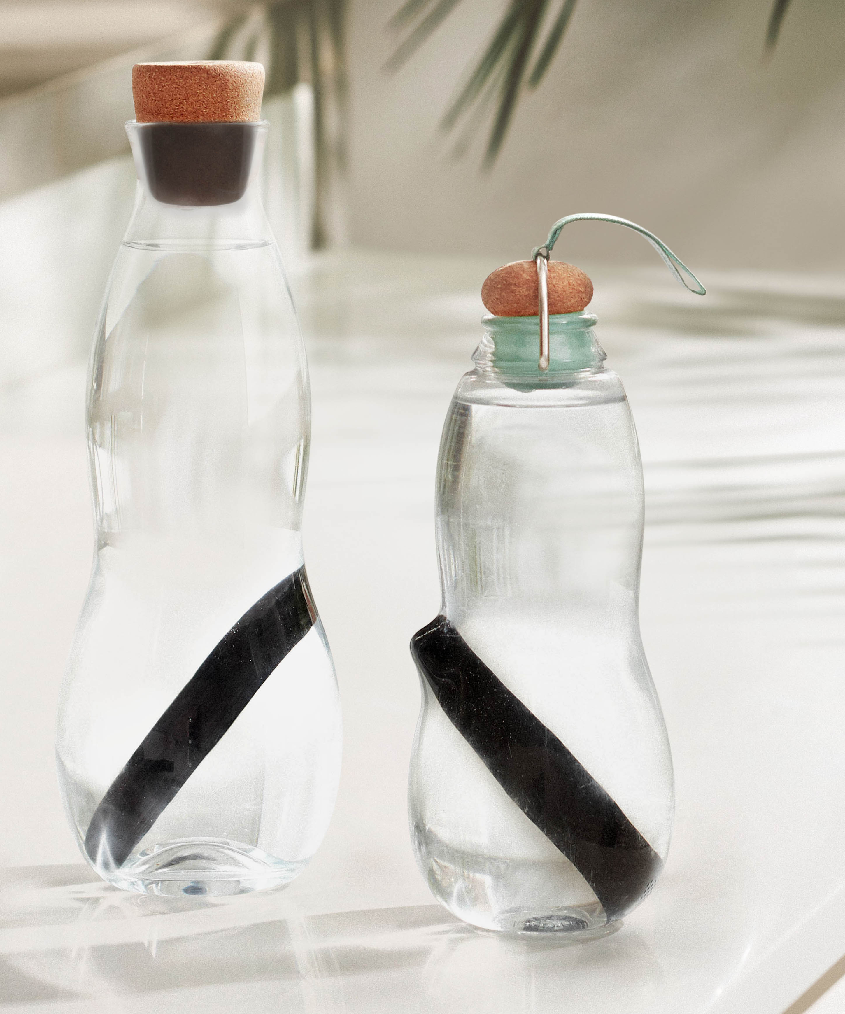 2 glass bottles with the Black + Blum charcoal filters with coil inside