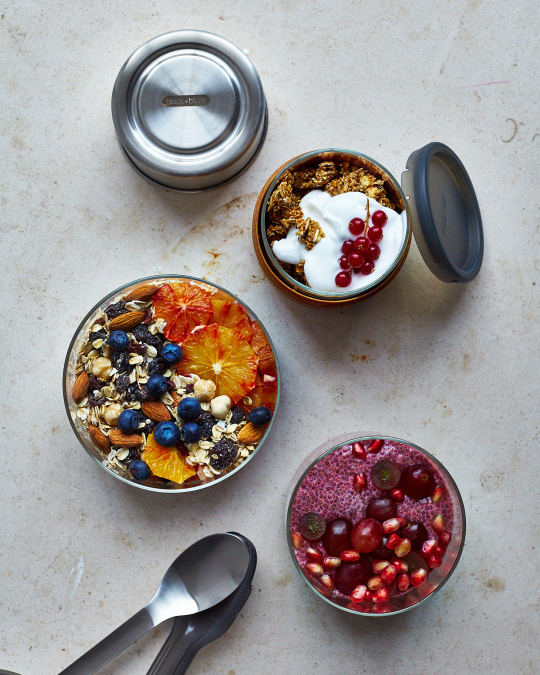 A top down view of the Black + Blum leakproof microwave safe glass lunchbowl showing different cereals inside the glass bowl and showing the silicone lid detail.