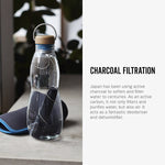 The charcoal filter and spring shown inside the glass bottle from black and blum long side text. The text reads, Charcoal filration. Japan has been using active charcoal to soften and filter water for centuries. As an active carbon, it not only filters and purifies water, but also air. It acts as a fantastic deodoriser and dehumidifier.