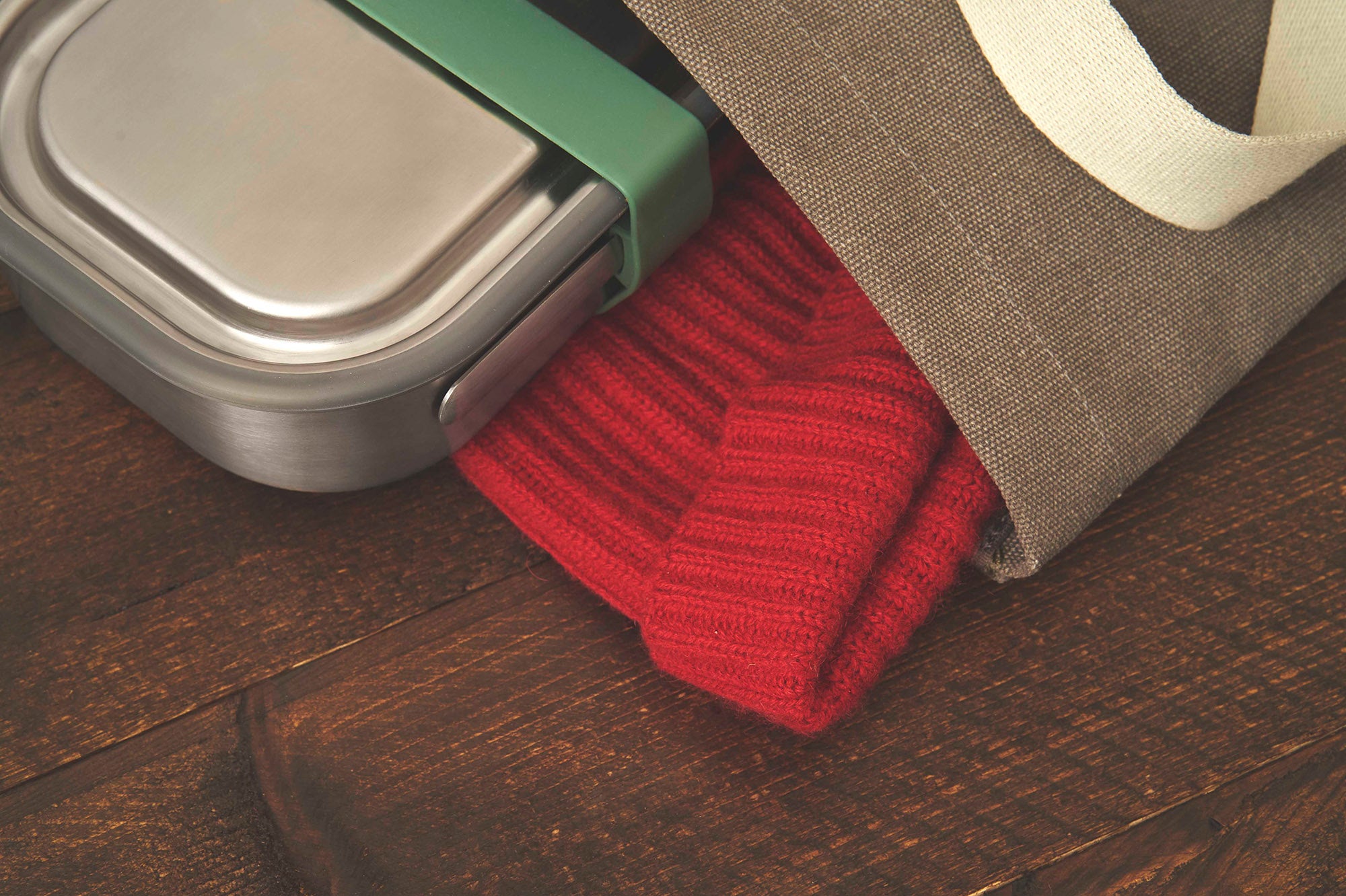 A close up of the small black + blum leakproof stainless steel lunchbox inside a canvas bag