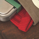 A close up of the small black + blum leakproof stainless steel lunchbox inside a canvas bag