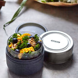 A close up of the Black + Blum leakproof microwave safe glass lunchbowl showing the protective leak proof stainless steel lid and wood case detail