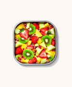 A close up of a Black + Blum square stainless steel leakproof microwave safe lunchbox showing different fruit inside the lunchbox
