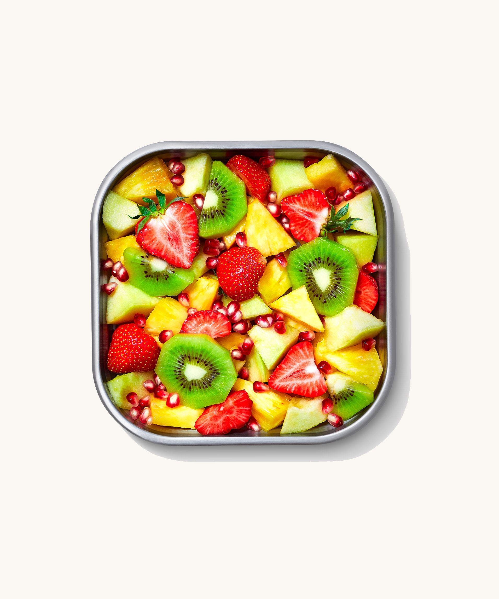 A close up of a Black + Blum square stainless steel leakproof microwave safe lunchbox showing different fruit inside the lunchbox