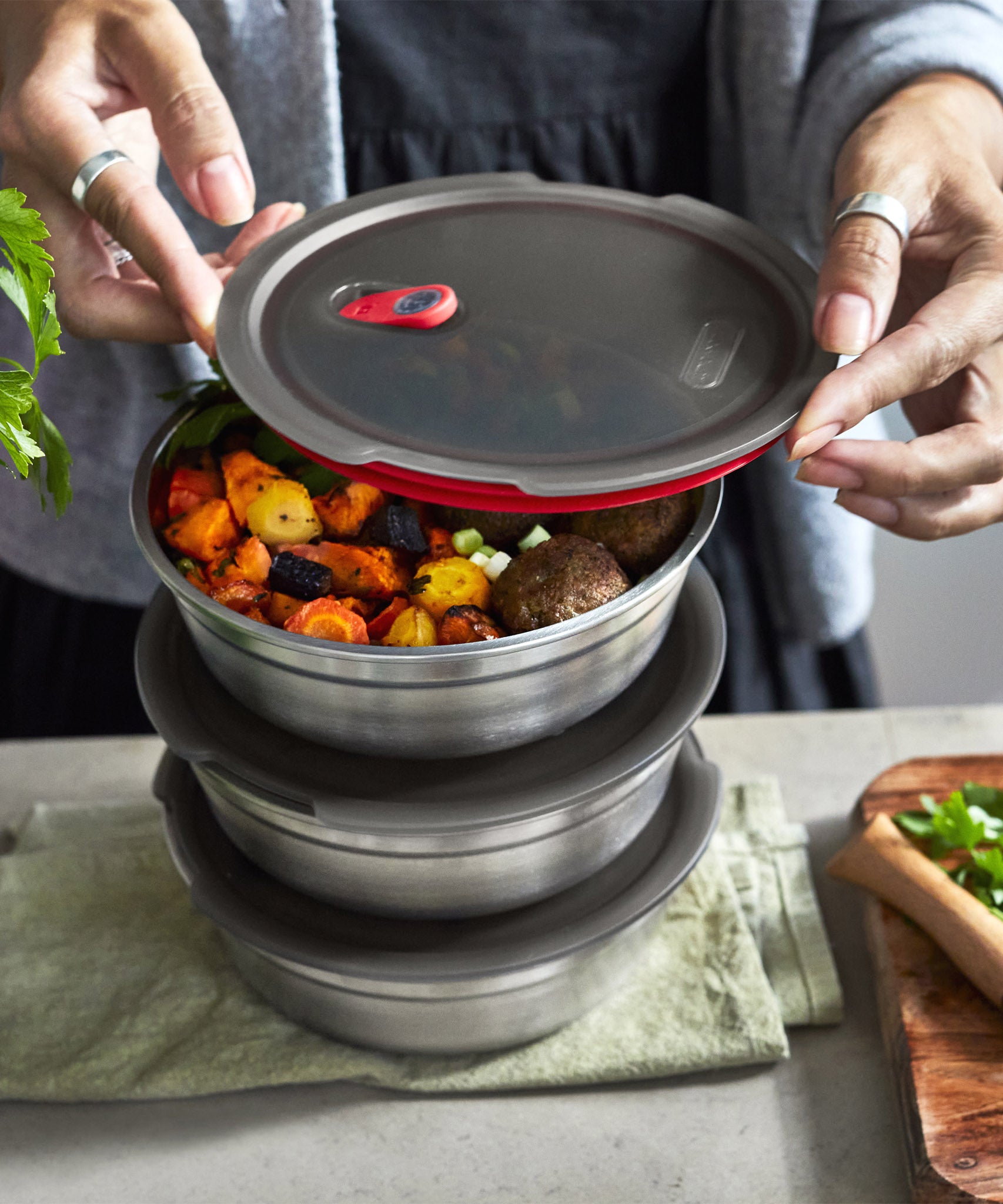 A close up of 3  Black + Blum stainless steel bowls stacked on top of each other on a kitchen worktop