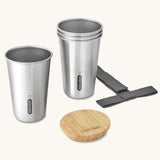 A close up of the set of 4 Black + Blum stainless steel cups showing the bamboo lid bottle opener detail and handy black carry strap