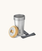 A close up of the set of 4 Black + Blum stainless steel cups showing the bamboo lid bottle opener detail