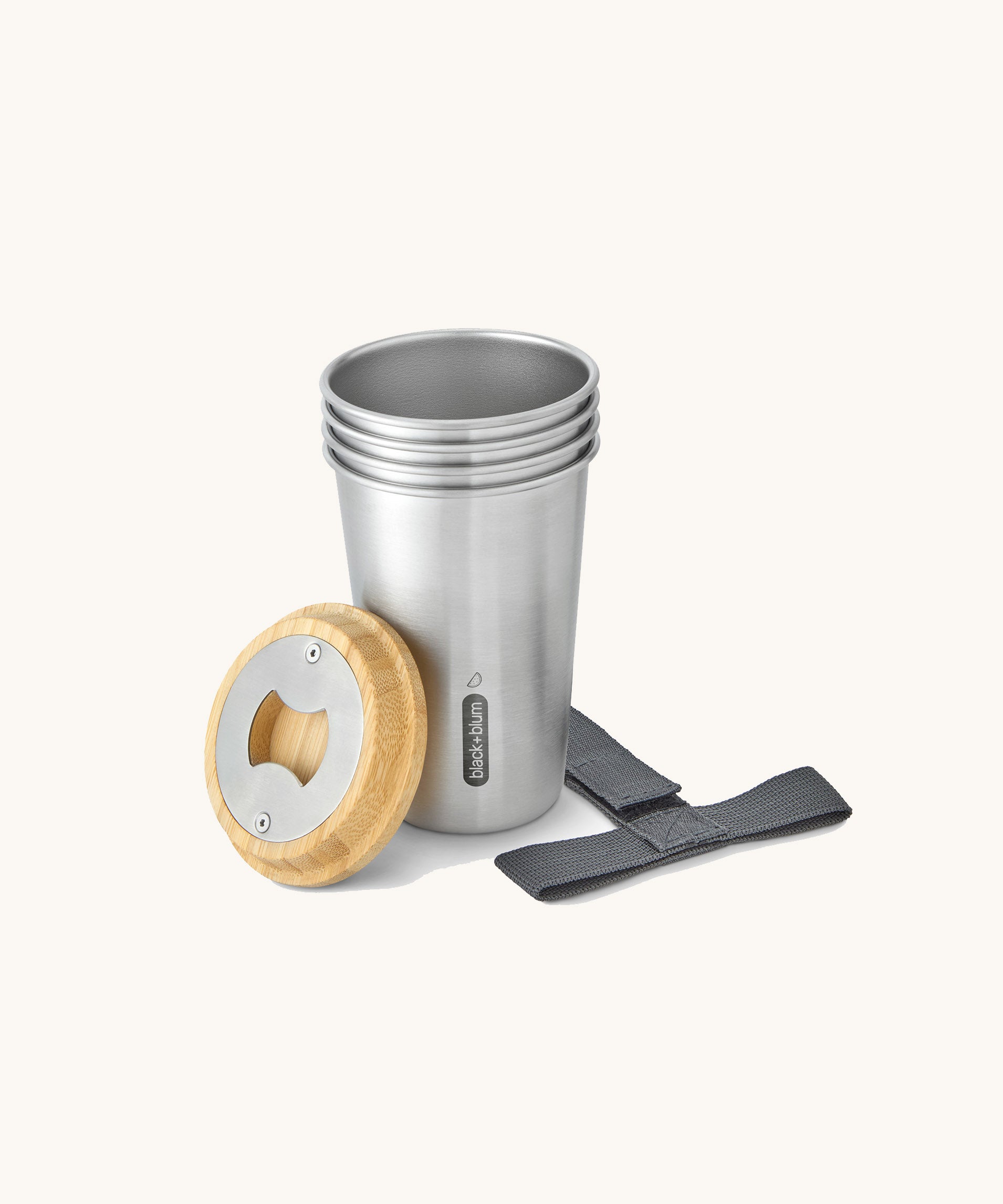 A close up of the set of 4 Black + Blum stainless steel cups showing the bamboo lid bottle opener detail