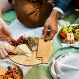 A close up of a couple of  adult having a picnic and using the Black + Blum stainless steel plates and using the bamboo lid as a chopping board