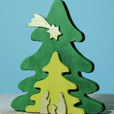 A Bumbu Christmas Tree Nativity Puzzle in the Gold colour way placed on a wooden surface.