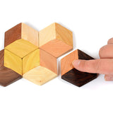Hand sliding pieces of the Bumbu handmade connect starter toy set together on a white background