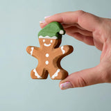 A hand holding the Bumbu gingerbread cookie boy