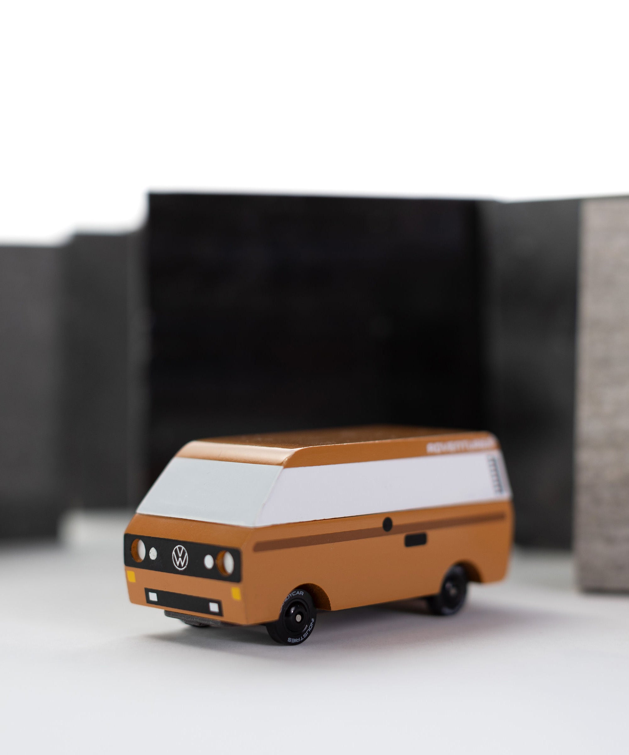CandyLab Volkswagen T3 Campervan in brown - front view, photographed with a blurred black and white background.