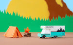Candylab collectable diecast rv toy next to a paper tent in front of a yellow mountain background