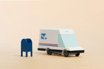 Candylab collectable wooden mail van toy on a beige background next to a miniature blue postbox