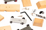 Pieces of the candylab childrens wooden car building kit scattered on a white background