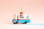 Candylab toy plumbing truck on a pink faded background next to a small blue puddle