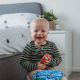 Young child sitting on a yellow potty in a bedroom