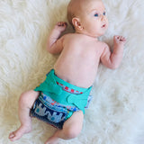 A baby wearing The Close Parent x Babipur exclusive pop-in reusable cloth nappy, in a clyd print