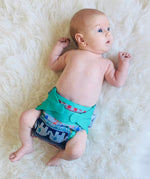 A baby wearing The Close Parent x Babipur exclusive pop-in reusable cloth nappy, in a clyd print