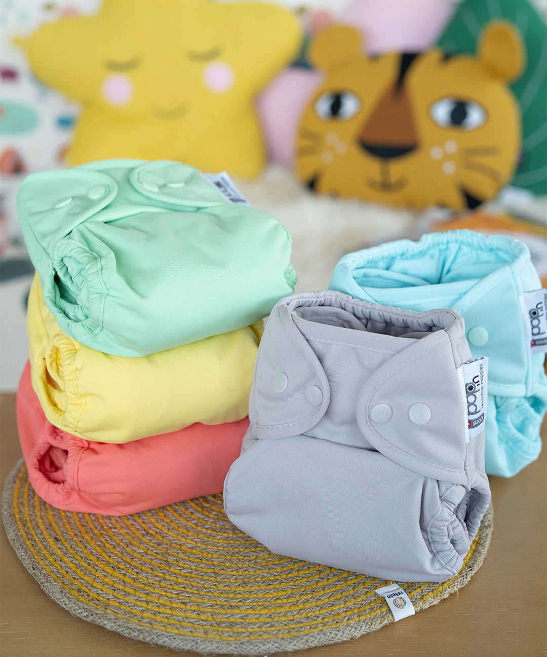 The Close Parent Pop-In reusable cloth nappies with popper fastenings, in pastel colours.
