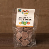 jar and scoop filled with Cocoa Loco organic Fairtrade chocolate buttons on a wooden table