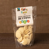 jar and scoop filled with Cocoa Loco organic Fairtrade chocolate buttons on a wooden table