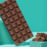 The Divine Tiramisu Dessert Bar shown unwrapped There are pieces that have been broken off by it's side along with coffee beans.