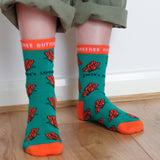 A close up of a child wearing the Eco Kiddies organic cotton butterfly socks showing the cute orange butterfly design and orange trim detail