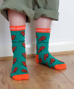 A close up of a child wearing the Eco Kiddies organic cotton butterfly socks showing the cute orange butterfly design and orange trim detail