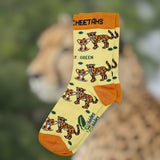 Eco kiddies organic cotton yellow cheetah socks on a background of a cheetah in a safari environment.