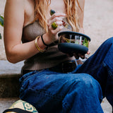 A close up of a woman holding the large Elephant box bowl. Bowl available at Babipur. Features a removable lid and a silicone base.