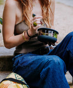 A close up of a woman holding the large Elephant box bowl. Bowl available at Babipur. Features a removable lid and a silicone base.