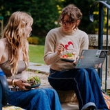 2 women sitting on stairs and eating food from the Elephant box bowls. The medium and large bowl are both available at Babipur.