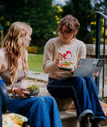 2 women sitting on stairs and eating food from the Elephant box bowls. The medium and large bowl are both available at Babipur.