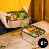 A man holding he Elephant Box Prep & Store medium food storage container with a grey silicone seal and see through glass lid.