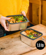 A man holding he Elephant Box Prep & Store medium food storage container with a grey silicone seal and see through glass lid.