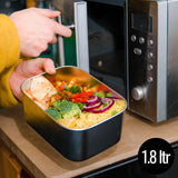 A man putting the Elephant Box Prep & Store medium food storage container in the microwave.