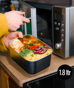 A man putting the Elephant Box Prep & Store medium food storage container in the microwave.
