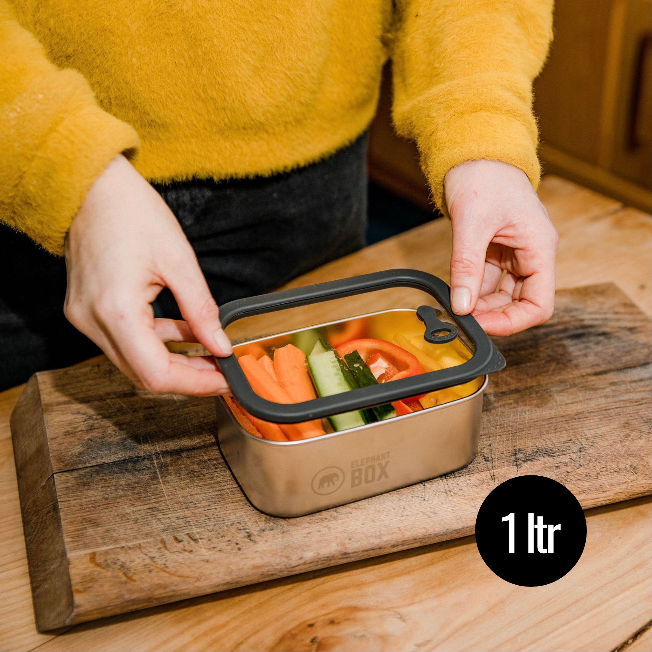 A man closing the Elephant Box Small Prep & Store food storage container, with a grey silicone lid.
