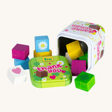 Erzi opened wooden chocolate cubes in a tin on a cream background.