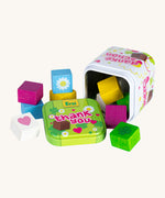 Erzi opened wooden chocolate cubes in a tin on a cream background.