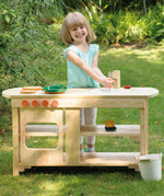 A child playing outdoors with the Erzi wooden toy kitchen and toy pots and pans.