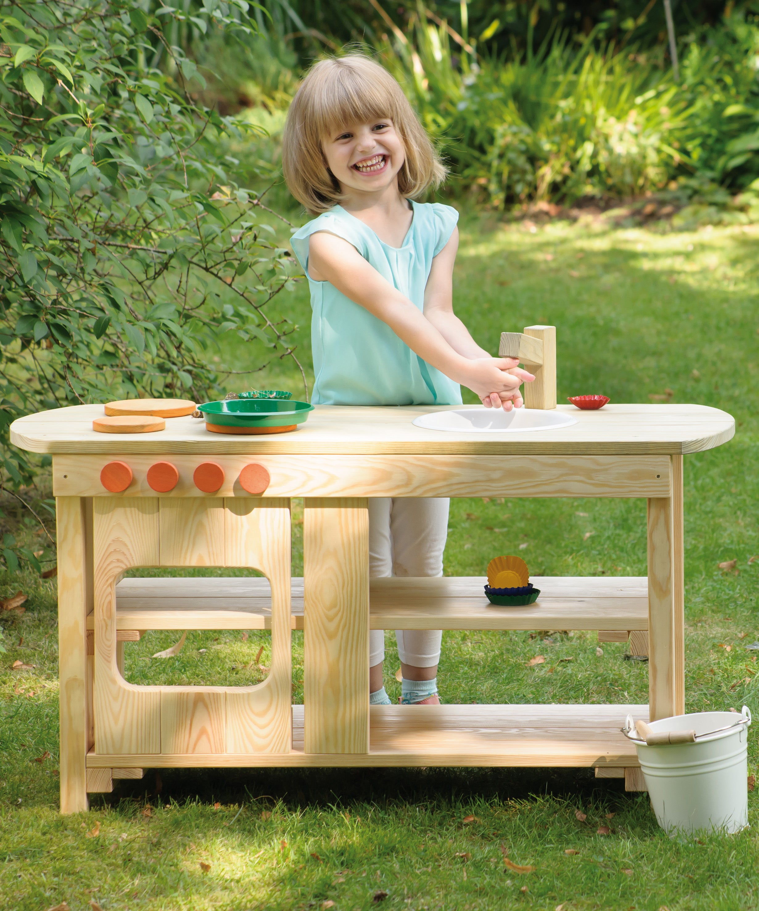 A child playing outdoors with the Erzi wooden toy kitchen and toy pots and pans.