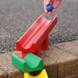 with a hand rolling some wooden balls down it