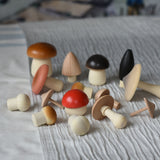 The wooden mushrooms from the Erzi Forest mushrooms in a box set placed on a striped tablecloth.