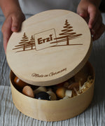 Erzi wooden painted forest toy mushrooms in a round wooden box. A child can be seen lifting the lid off the box.