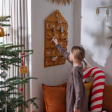 Girl on her knees pulling a toy out from the Fabelab organic cotton Christmas calendar
