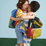 Two children each wearing a Fluf junior organic cotton backpack.